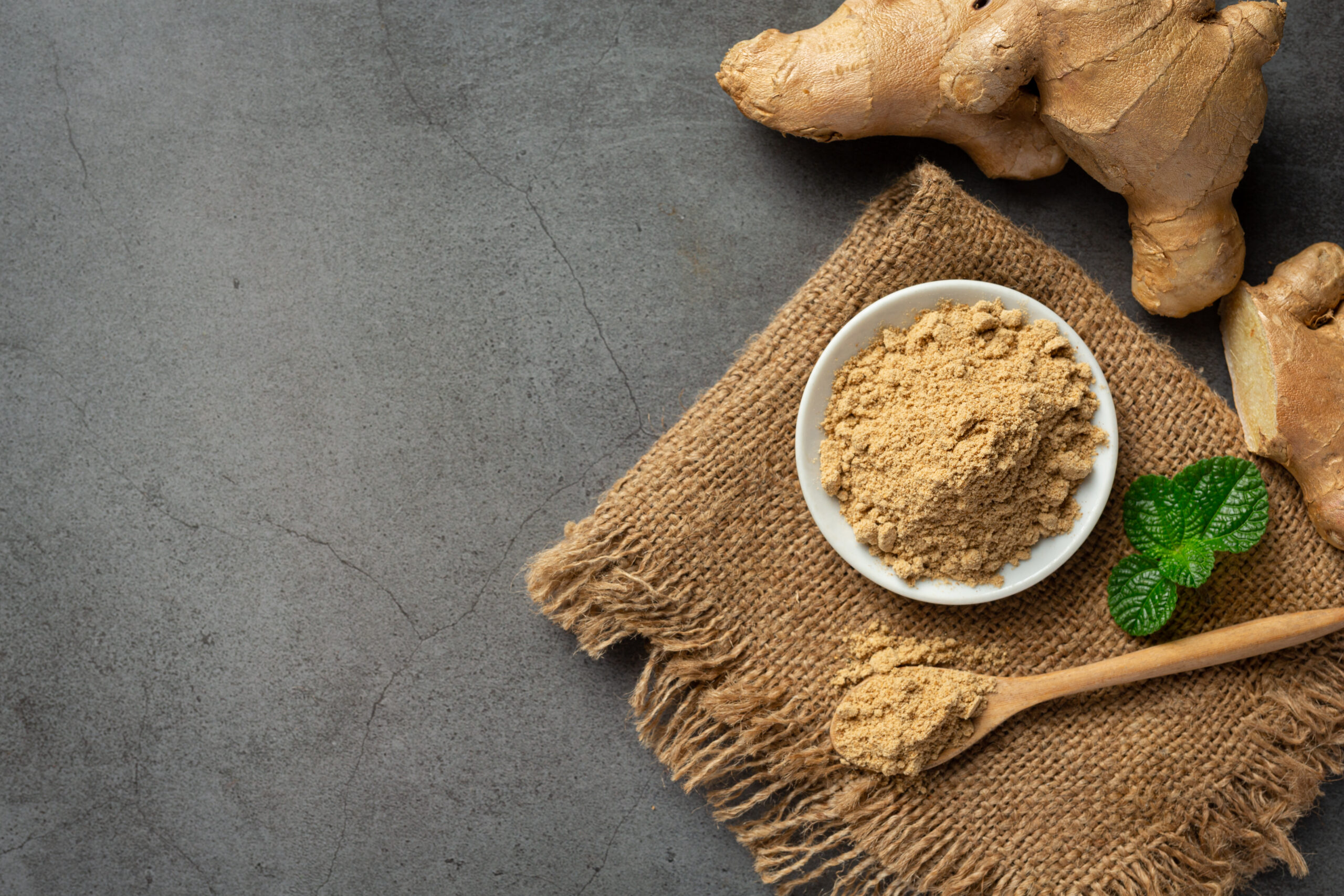 Ginger root and ginger powder on table